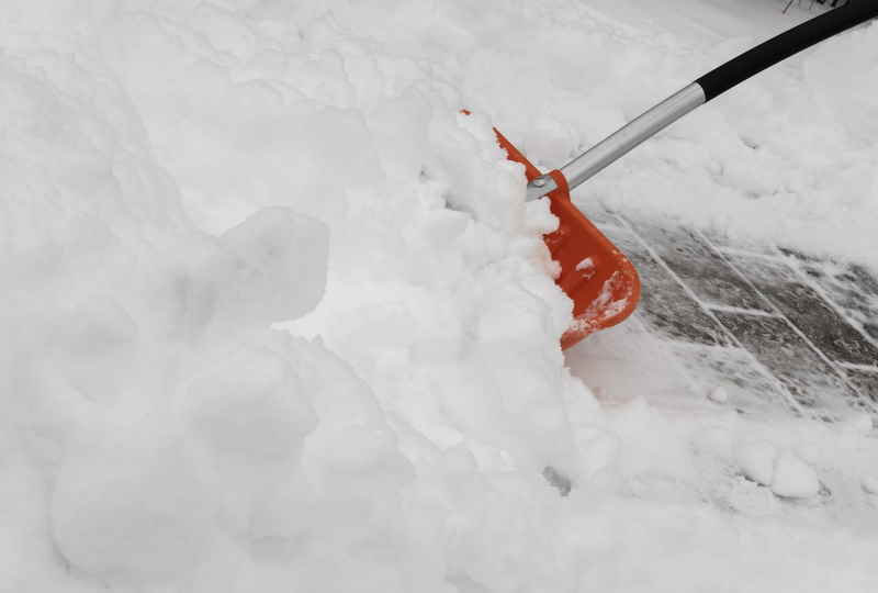 Schneeschaufel räumt Gehweg vom Schnee